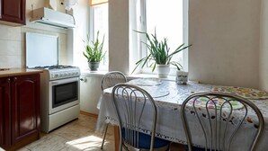 A kitchen with a stove, oven, and potted plants. - Home-Hotel Streletskaya 28 (Kyiv)