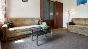 A living room with two sofas, a glass coffee table, a wooden cabinet, and a floor lamp. - Home-Hotel Streletskaya 28 (Kyiv)