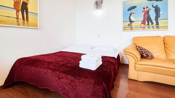 Una habitación de hotel con una cama, un sofá y dos cuadros en la pared.