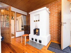 A cozy room with a fireplace, wooden flooring, and a door leading to another area. - Villa-lyydia by Interhome (Hämeenlinna)