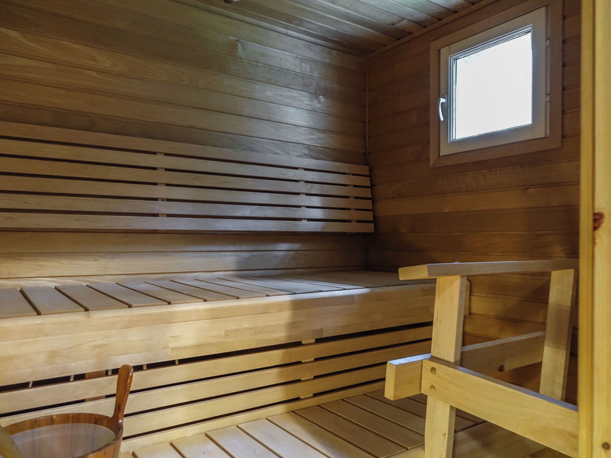 A sauna with wooden benches and a window.