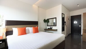 A modern hotel room with a large bed, a nightstand, a mirror, and a small desk with a lamp. - Privato Makati (Makati)