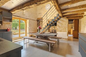 Eine moderne Küche mit einer Steinwand, einer Holztreppe und einem großen Fenster.