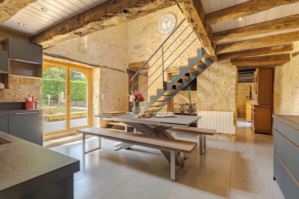 Eine moderne Küche mit einer Steinwand, einer Holztreppe und einem großen Fenster.