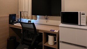 A hotel room with a desk, a computer, a TV, a microwave, and a trash can. - HOTEL R9 The Yard Kanumasakae (Kanuma)