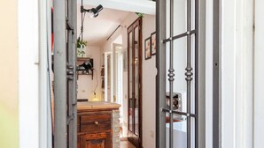 A hallway with a wooden cabinet, a door with glass panels, and a white wall.
