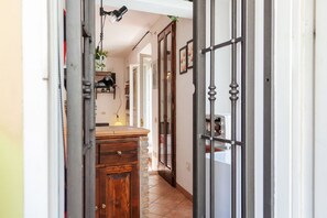 A hallway with a wooden cabinet, a door with glass panels, and a white wall.