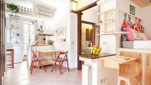 A kitchen with a dining area, a radiator, and a wooden stool.