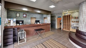 A reception area with a counter, seating, and a display of amenities. - Ichihara Inn Social Goi (Ichihara)