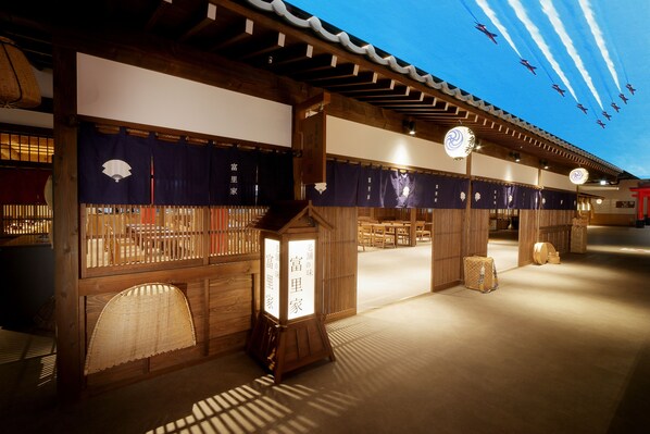 Um edifício tradicional japonês com piso de esteiras de tatame, vigas de madeira e painéis shoji.