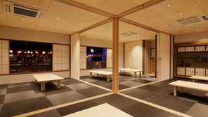 A traditional Japanese-style room with tatami flooring, low wooden tables, and sliding doors. - Yurakujo (Tomisato)