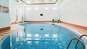 An indoor swimming pool with a tiled floor, a ladder, and a ceiling with recessed lighting. - Asia Hotel Fergana (Fergana)
