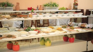 A buffet with multiple food stations and decorative elements like flowers and figurines. - Asia Hotel Fergana (Fergana)