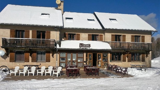 A building with a sign reading "la Draye" and outdoor seating with tables and chairs. - Gite de la Draye (Crots)