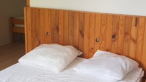 A bed with a wooden headboard and two pillows. - Gite de la Draye (Crots)