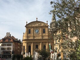 Un edificio histórico con una torre de reloj, que presenta una cúpula central y ventanas de arco.