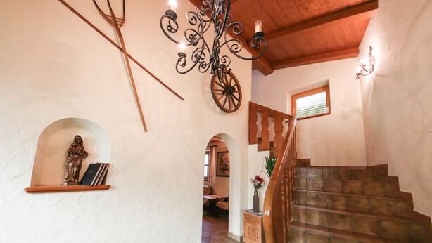 Eine Treppe mit Holzboden und einem Holengeländer, die zu einer zweiten Etage führt.