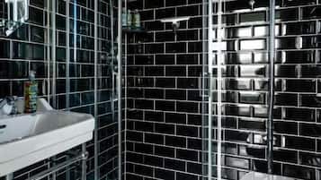Un baño con ducha de vidrio, inodoro blanco y lavamanos.