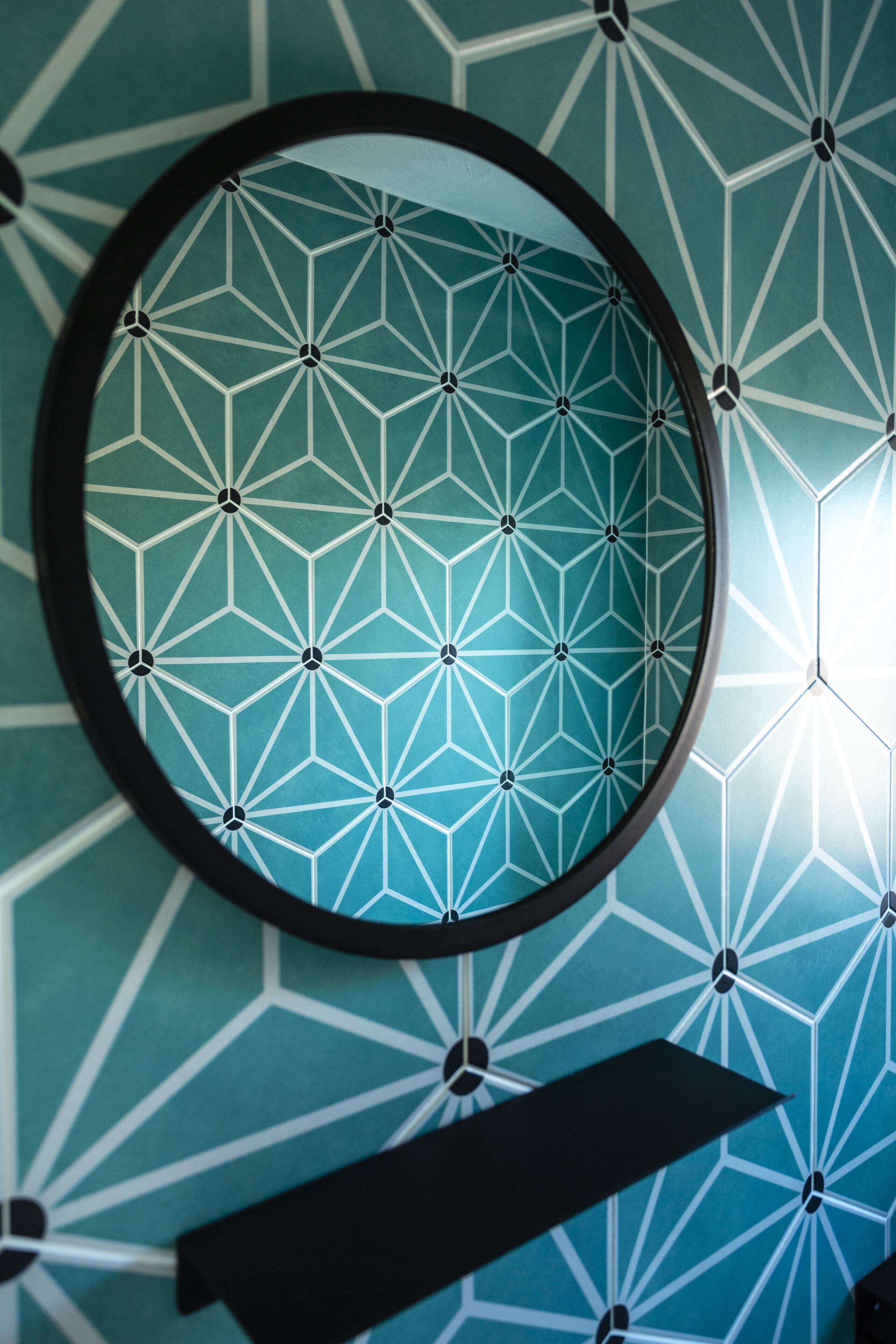 Pared con un diseño geométrico y un espejo circular.