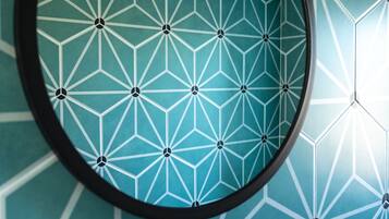 Pared con un diseño geométrico y un espejo circular.