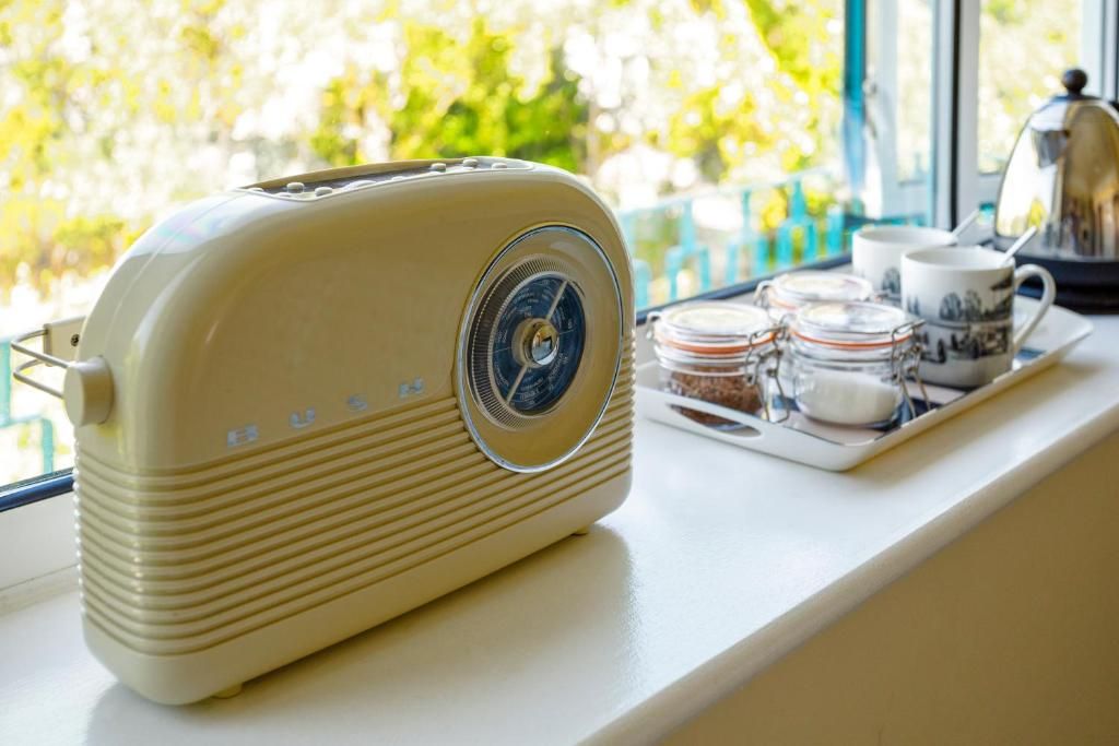 A vintage radio on a windowsill with a tray of tea and sugar.