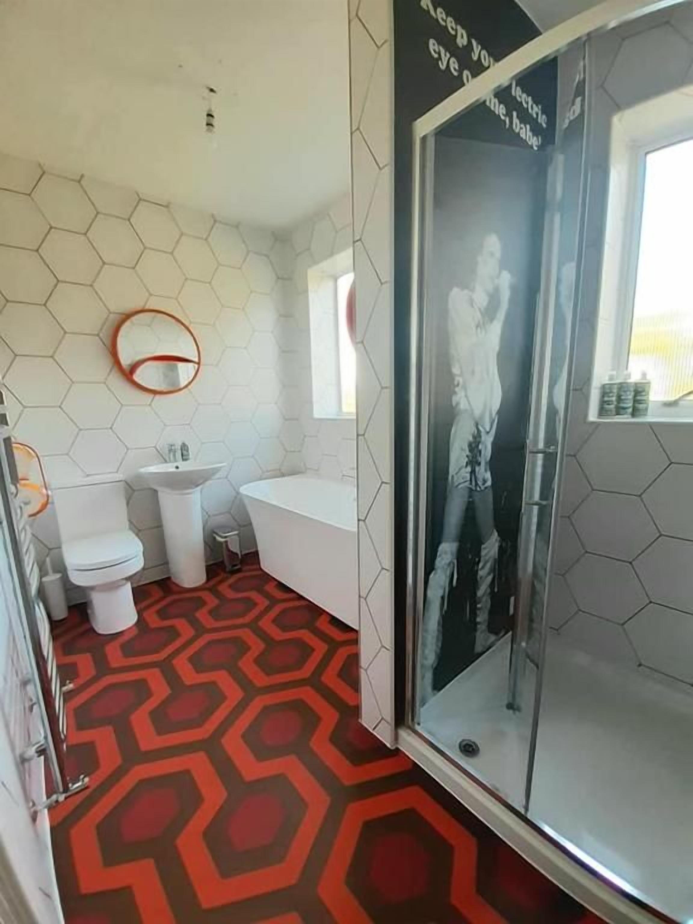 A bathroom with a shower, toilet, and bathtub.
