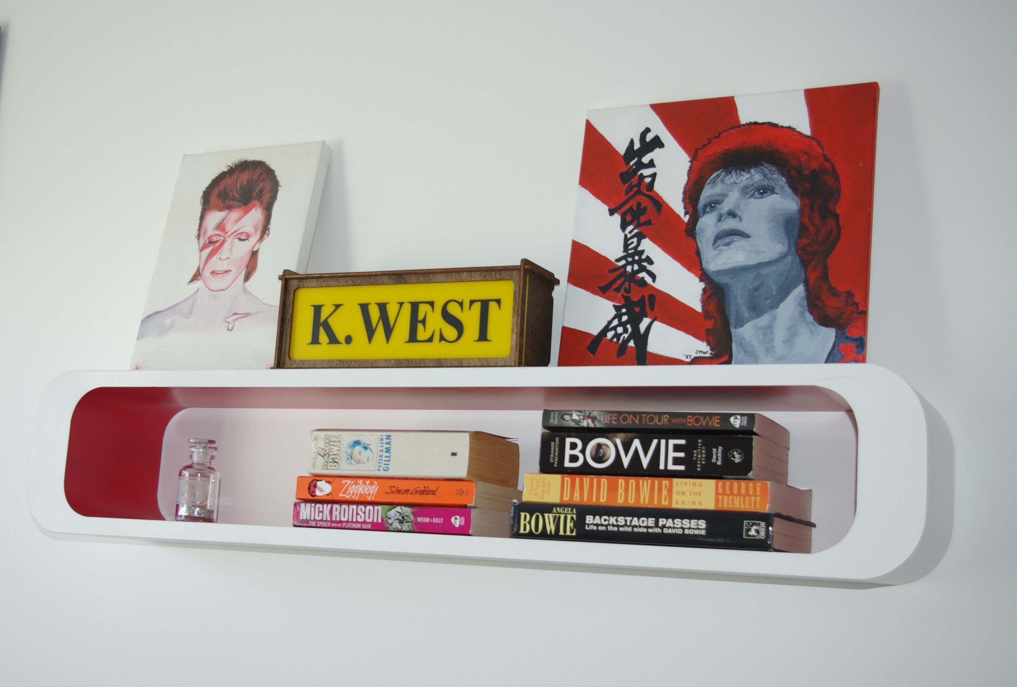 A bookshelf with books and a framed picture.