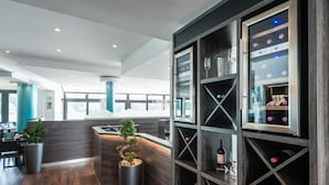 A modern hotel lobby with a reception desk, seating area, and wine display. - Rheinterrassen Hotel Café Restaurant (Bornheim)