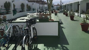 A courtyard with potted plants, bicycles, and outdoor seating. - Holiday Apartment, Beautiful one bedroom apartment, near to all amenities (Puerto del Carmen)