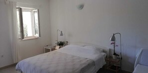 A simple, clean room with a bed, two bedside tables, a window, and a potted plant. - Apartments Grbin - Adults Only (Lumbarda)