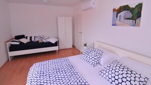 A bedroom with a bed, a sofa, a wardrobe, and a painting on the wall. - Apartments An Ni - Adults Only (Korcula)