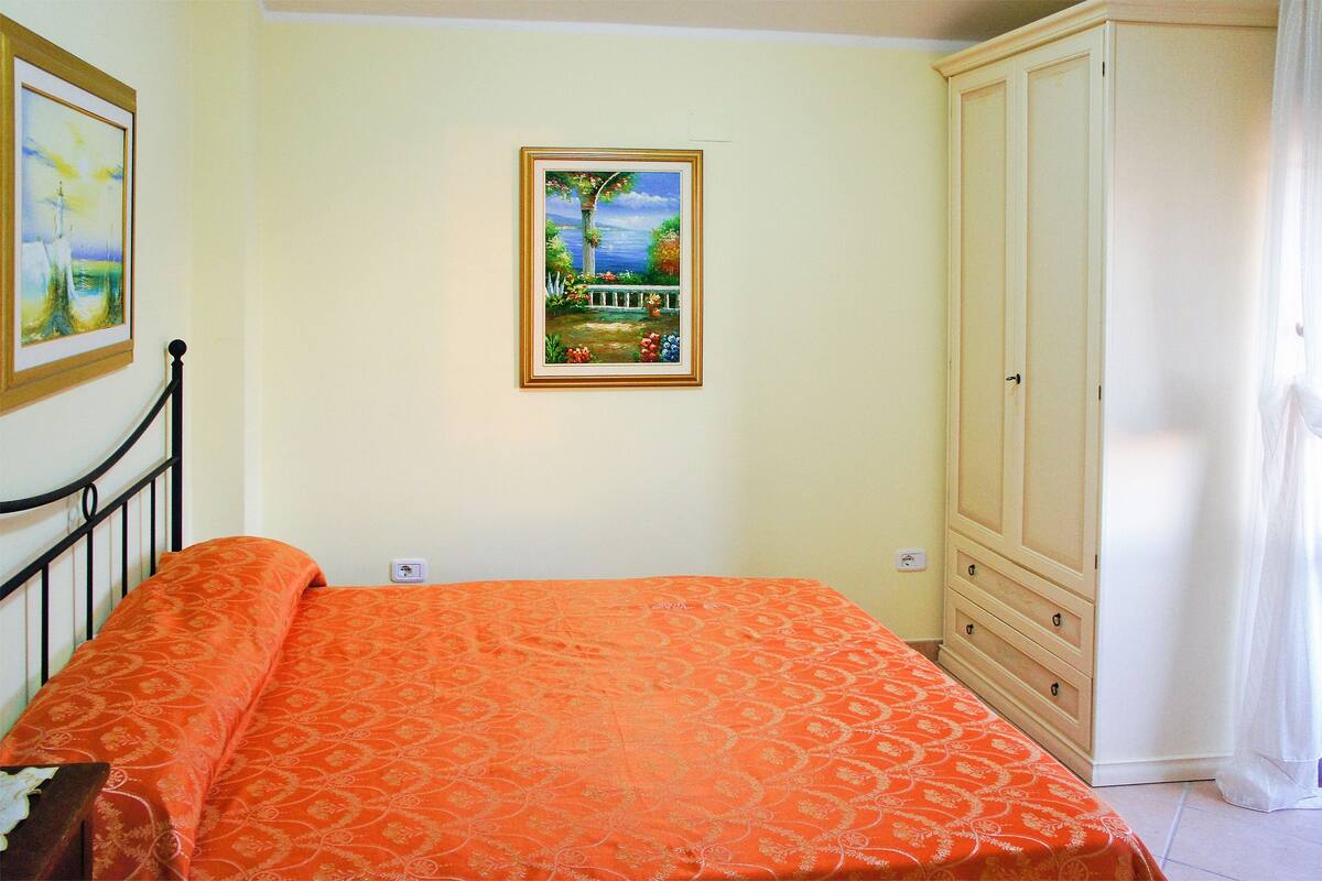 Une chambre à coucher avec un lit, une armoire et un tableau encadré accroché au mur.