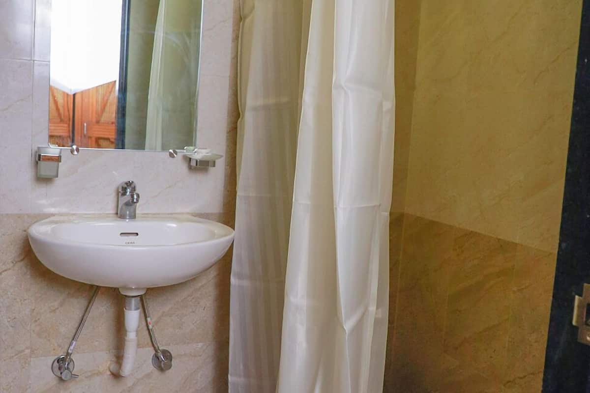A bathroom with a white sink, a mirror, and a shower curtain.