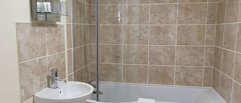 Een badkamer met toilet, wastafel en bad.
