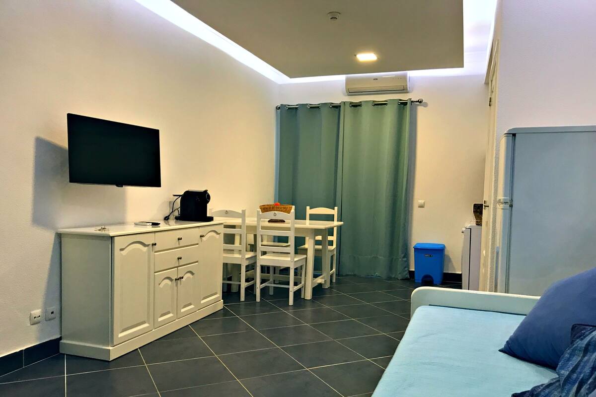 A compact room with a kitchenette, a dining area, and a seating area.