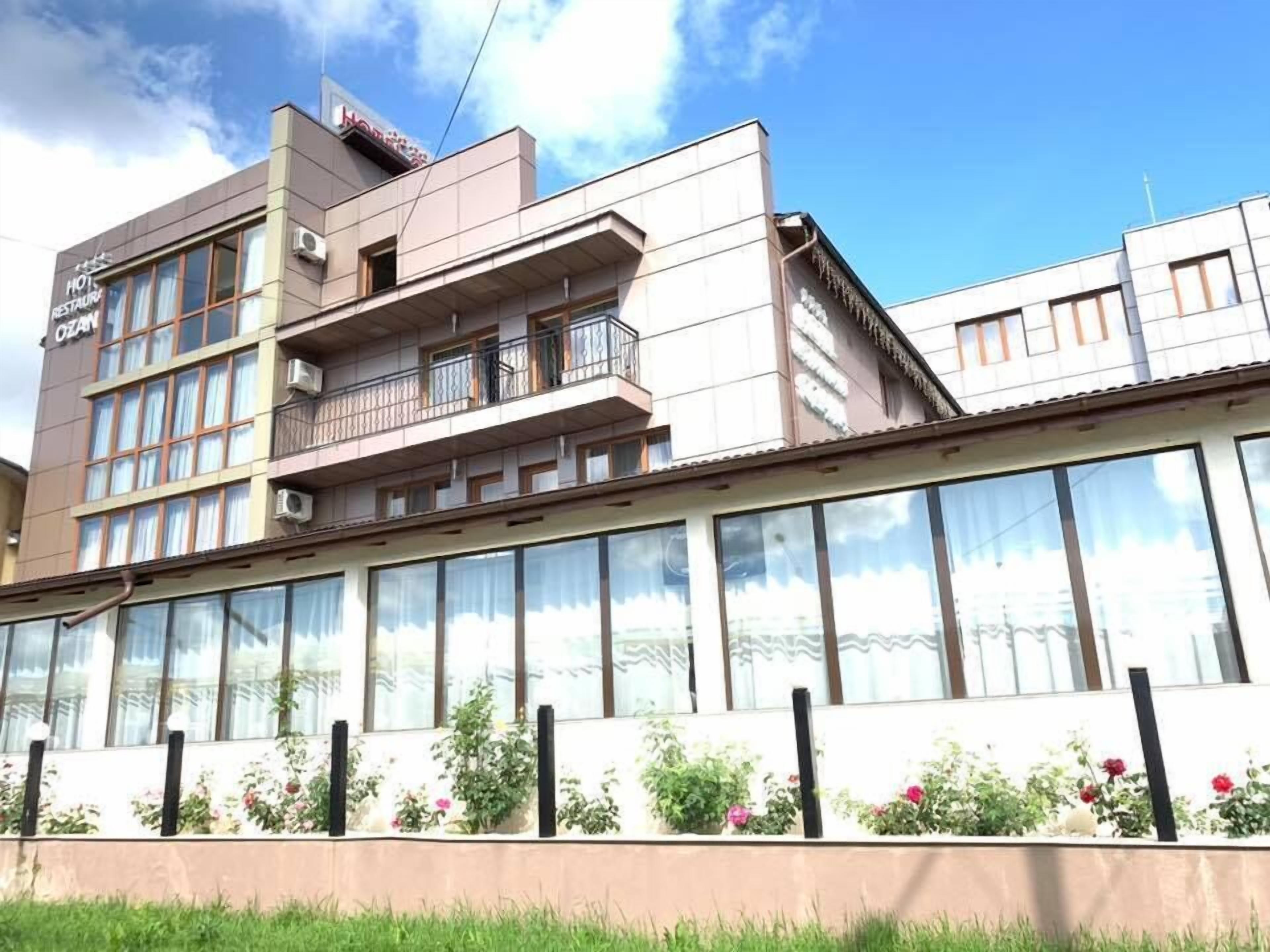 Un hotel amb façana moderna, grans finestres i teulada plana.