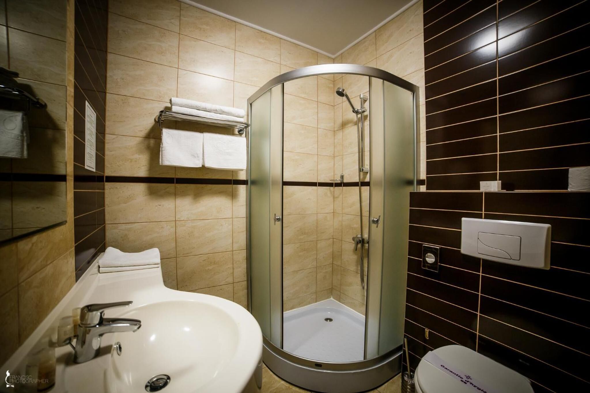 Un baño con ducha de vidrio, lavamanos y retrete.