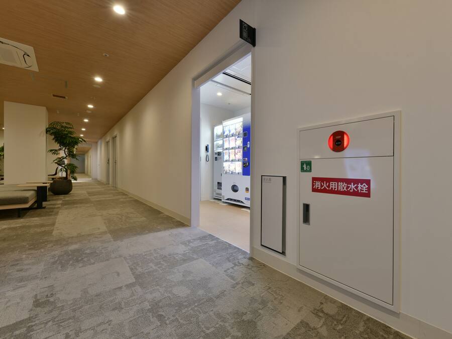 A hallway with a fire hydrant and a sign indicating a fire hose connection point.