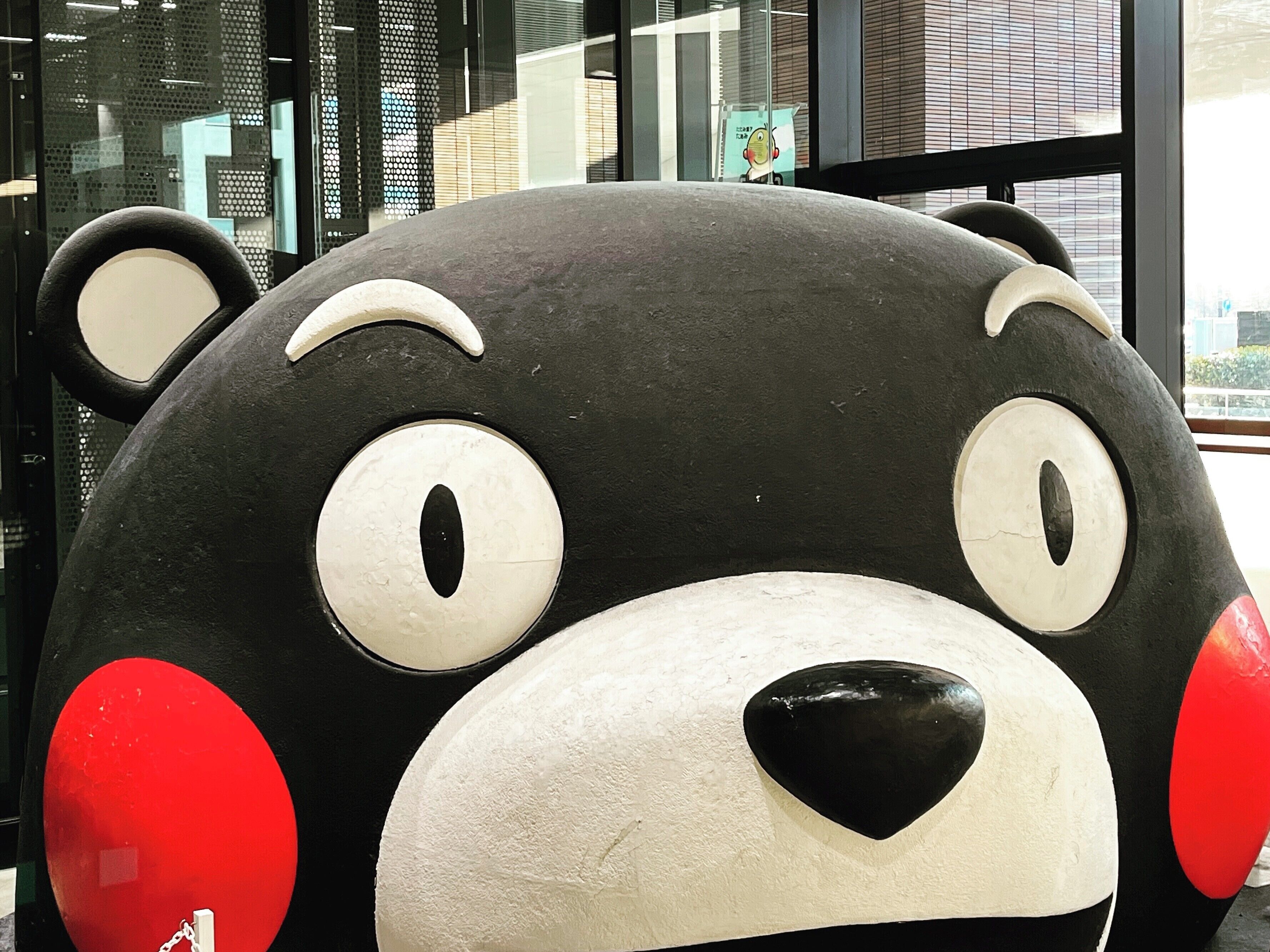A large plush bear statue with a black and white color scheme and red accents.