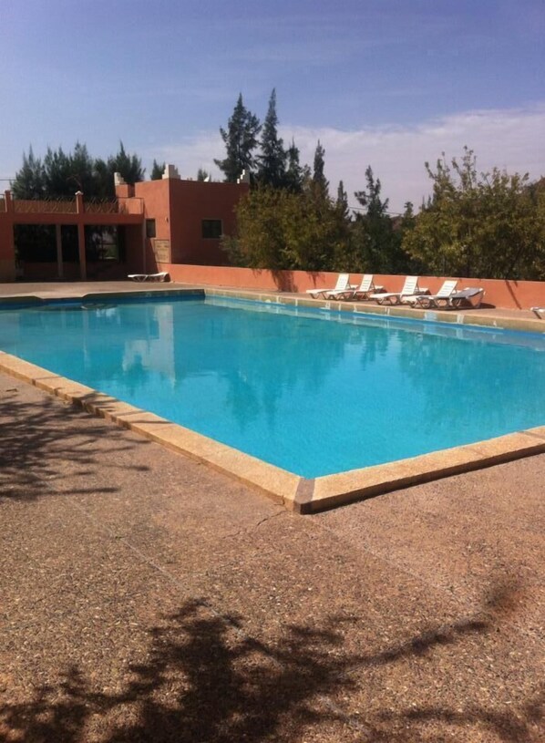 Alberca al aire libre y camastros 