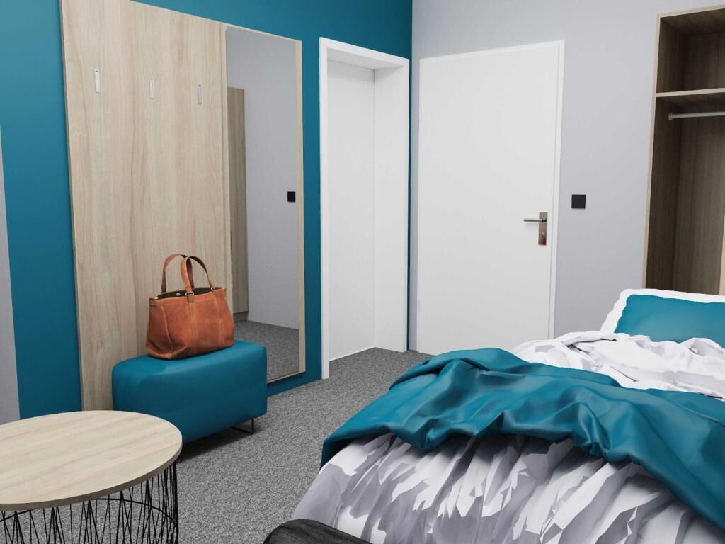 Un dormitorio con una cama, una mesa redonda, un banco azul, un bolso marrón y un armario.