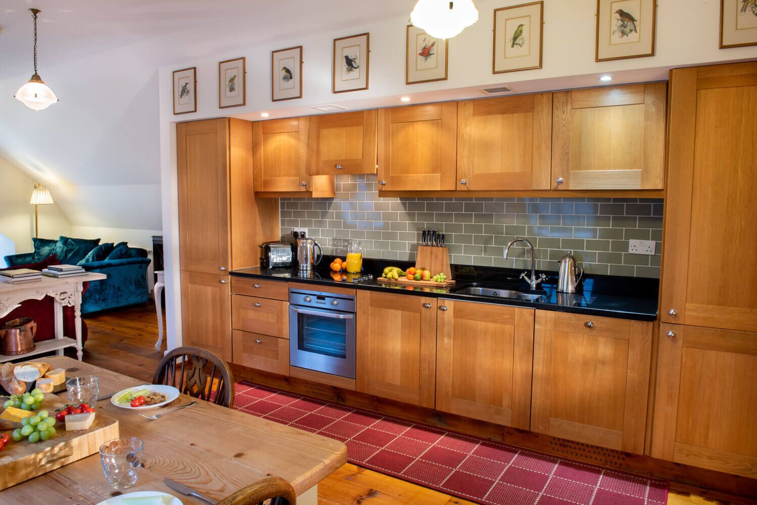 A modern kitchen with wooden cabinets, a built-in oven, and a black countertop.