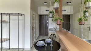 Una cucina moderna con zona pranzo, una pianta sospesa e un portascope in metallo.
