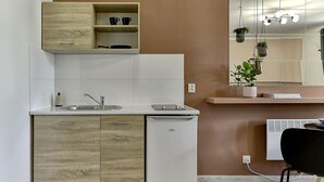 Una cucina moderna con un lavello doppio, una lavastoviglie integrata e un pensile in legno sopra il lavello.