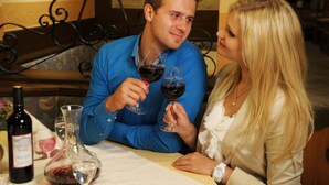 A man and a woman sitting at a table with wine glasses, a bottle of wine, and a decanter. - Gasthof Mühle Natur- & Wanderhotel (Rinchnach)