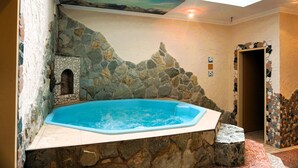 Un área de spa con pared de piedra, un pequeño rincón y un jacuzzi.