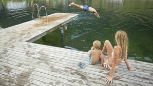 Un muelle de madera que se adentra en un lago, con una plataforma de salto.
