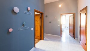 A hallway with a blue wall, wooden doors, and a tiled floor. - Your home in Trequanda (Trequanda)