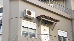A multi-story building with a stairwell, a garage door, and a balcony.