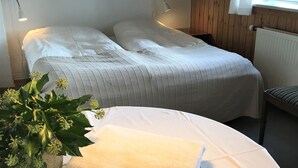 A bedroom with two beds, a potted plant, a chair, and a radiator. - Spangsgaard bed and breakfast (Odense)